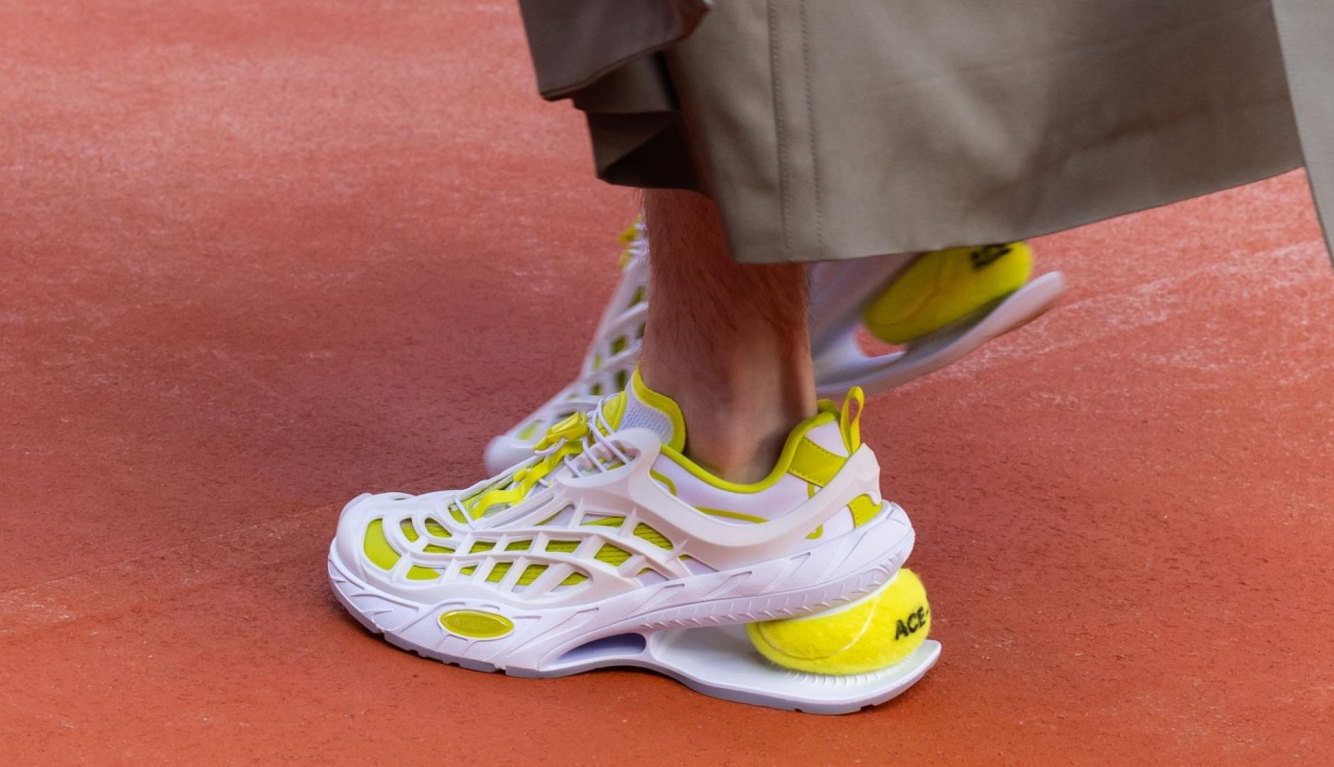 Lacoste places a tennis ball under a wedge shoe and brings clay to its new collection