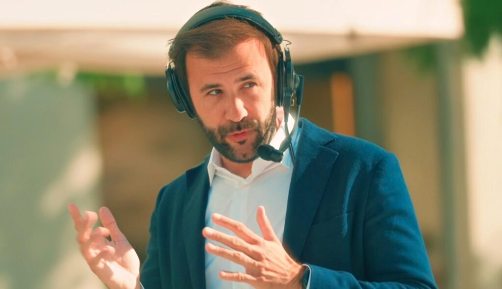 Carlos García Trillo con los auriculares hablando por la calle en Luz & Luces